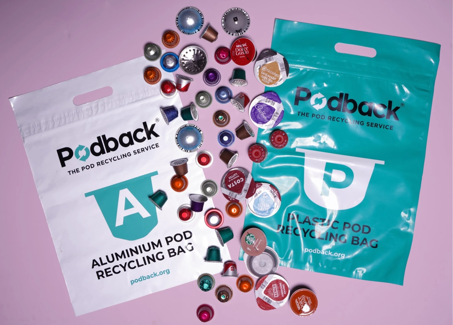 Podback aluminium and plastic pod recycling bags surrounded by used coffee pods
